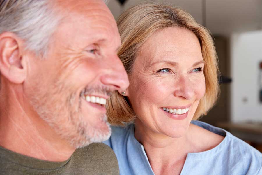 full-arch Smiling older couple with healthy, confident smiles after dental care.