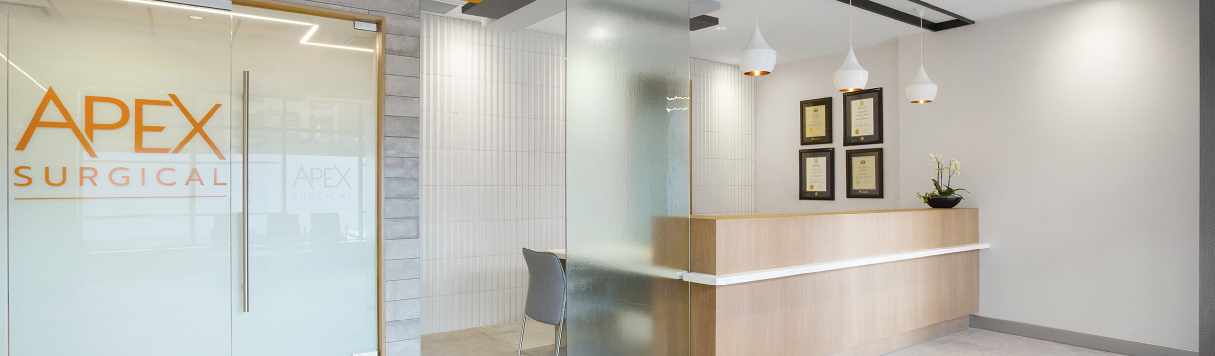Modern Apex Surgical oral surgery clinic reception area in Kamloops with glass entrance and wood front desk.