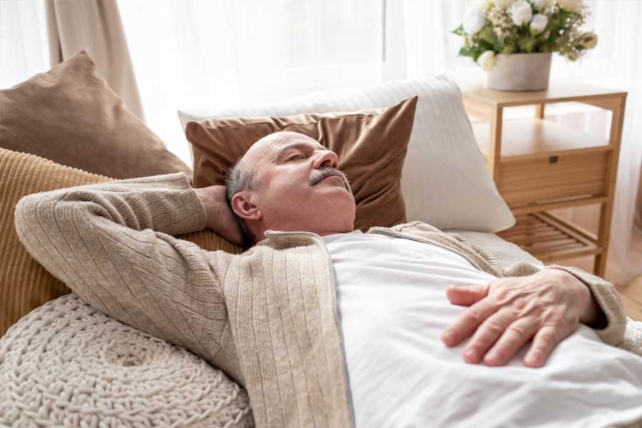 Older man resting at home, representing sleep apnea evaluation and oral surgery treatment options.